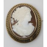 A CLASSICAL THEMED CAMEO BROOCH finely carved with a maiden with flowers in her hair. In a
