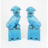 A PAIR OF CHINESE SHISHI each seated on a pierced base, one with brocade ball the other a cub,