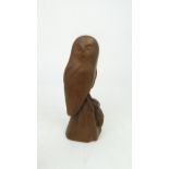 A CARVED WOODEN SCULPTURE OF A BARN OWL modelled holding a mouse in its claws, initialled IM to