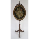 A VICTORIAN WALNUT TAPESTRY POLE SCREEN with oval tapestry panel supported on barley twist tripod