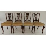 A lot of four Victorian mahogany framed dining chairs with stylized backs above upholstered seats on