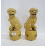 A pair of mustard glazed fo dogs, one with a ball, the other a small creature Condition Report: