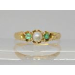A bright yellow metal ring set with emeralds and a split pearl, size L, weight 1.6gms Condition