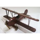 A large wooden model of an early 20th century bi-plane, with goggled pilot  Condition Report: