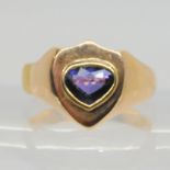 A gents yellow metal shield shaped signet ring set with a blue gem, stamped 9, finger size V, weight