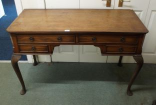 An early 20th century mahogany desk with two long over two short drawers on cabriole supports,