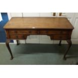 An early 20th century mahogany desk with two long over two short drawers on cabriole supports,