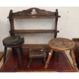 An early 20th century oak arts and crafts style three tier wall shelf, a circular stool carved