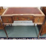 An early 20th century walnut ladies writing desk with red leather skiver over three drawers on