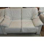 A 20th century white leather upholstered two seater sofa, 85cm high x 140cm wide x 95cm deep