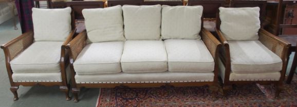 A 20th century mahogany framed bergere three piece suite with two seater sofa and pair of