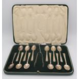 A cased set of twelve silver spoons and sugar tongs, with shaped terminals, by C W Fletcher & Son,