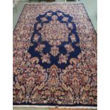 A dark blue ground eastern style wool rug with floral foliate central medallion and borders, 501cm