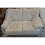 A 20th century white leather upholstered two seater sofa, 85cm high x 140cm wide x 95cm deep