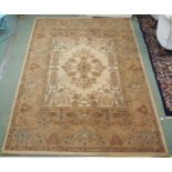 A modern cream ground machine made rug with floral central medallion and flower head border, 287cm