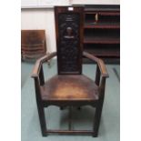 A Victorian baronial style hall armchair with carved back panel on stretchered supports, 121cm