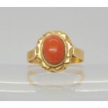 A bright yellow metal ring with Egyptian hallmarks and set with a coral, size S, weight 5.8gms