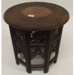 A 20th century Moorish style circular top table with folding octagonal base carved with floral