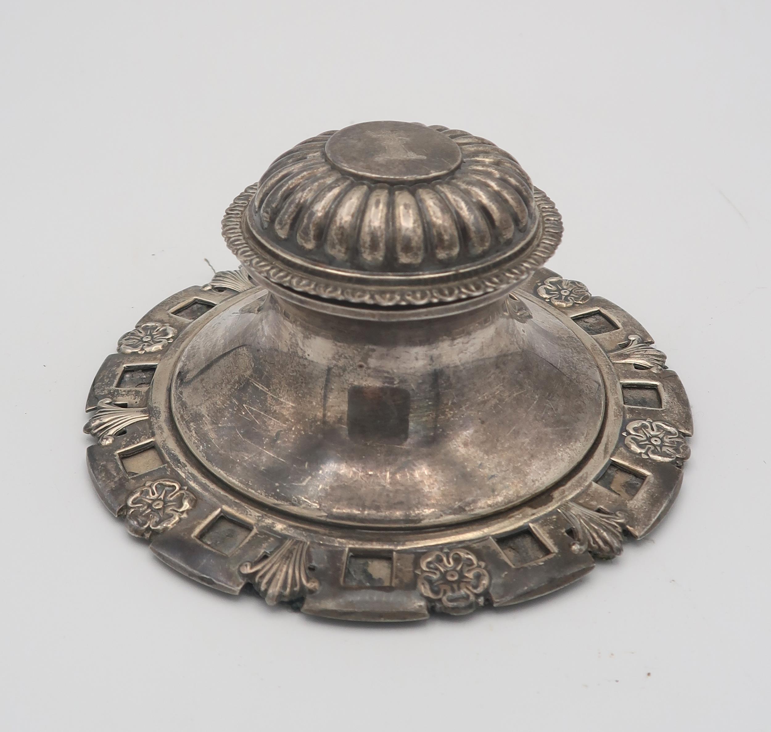 An Edwardian large silver capstan inkwell, the base decorated with cinquefoils and leaves, the lobed