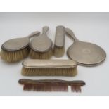 A five piece silver dressing table set, comprising two clothes brushes, two hair brushes a mirror