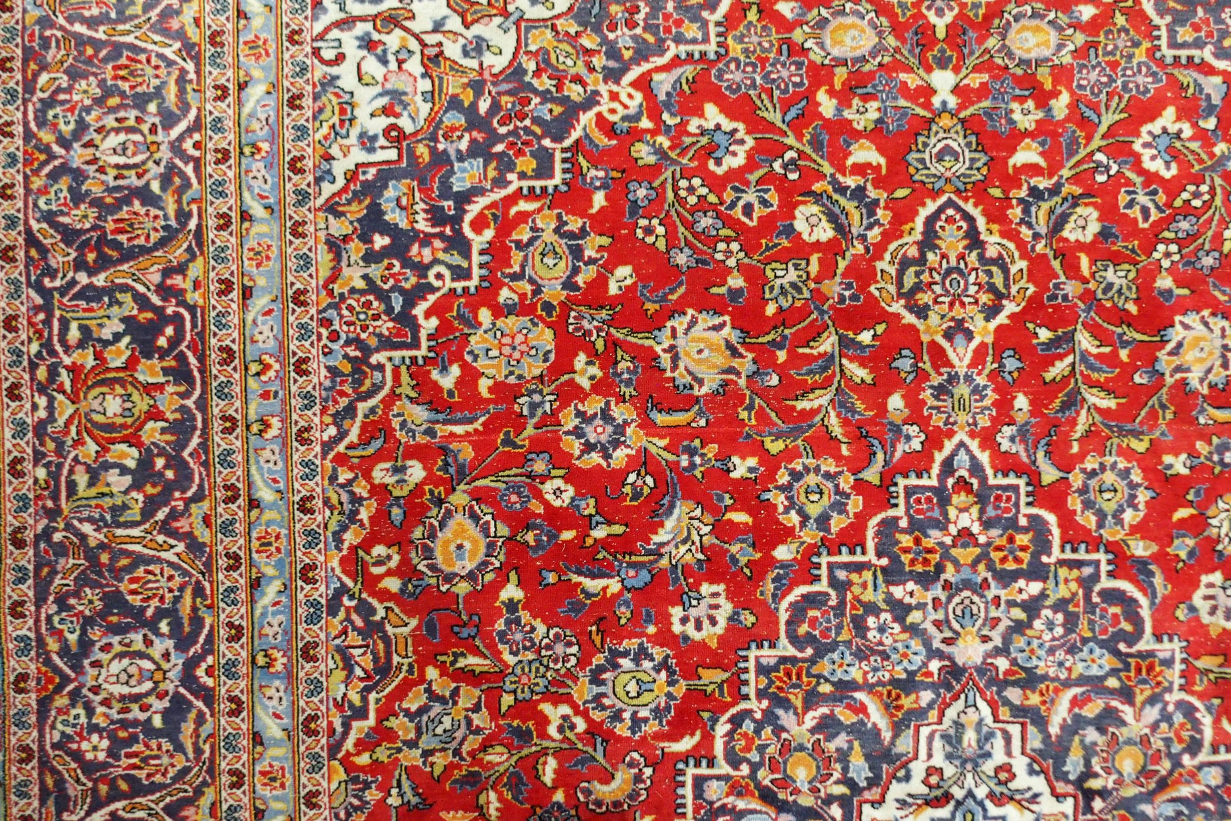 A red ground Kashan wool rug with a blue and cream central medallion, matching spandrels and a - Image 5 of 5