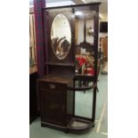 A late Victorian stained oak mirror backed hall stand with oval bevelled glass mirror over single