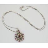A white metal ruby set flower pendant, diameter 2.1cm, with an 18k white gold box chain length 50cm,