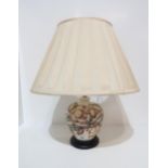 A Moorcroft table lamp with pink flowers on a cream background Condition Report:Available upon