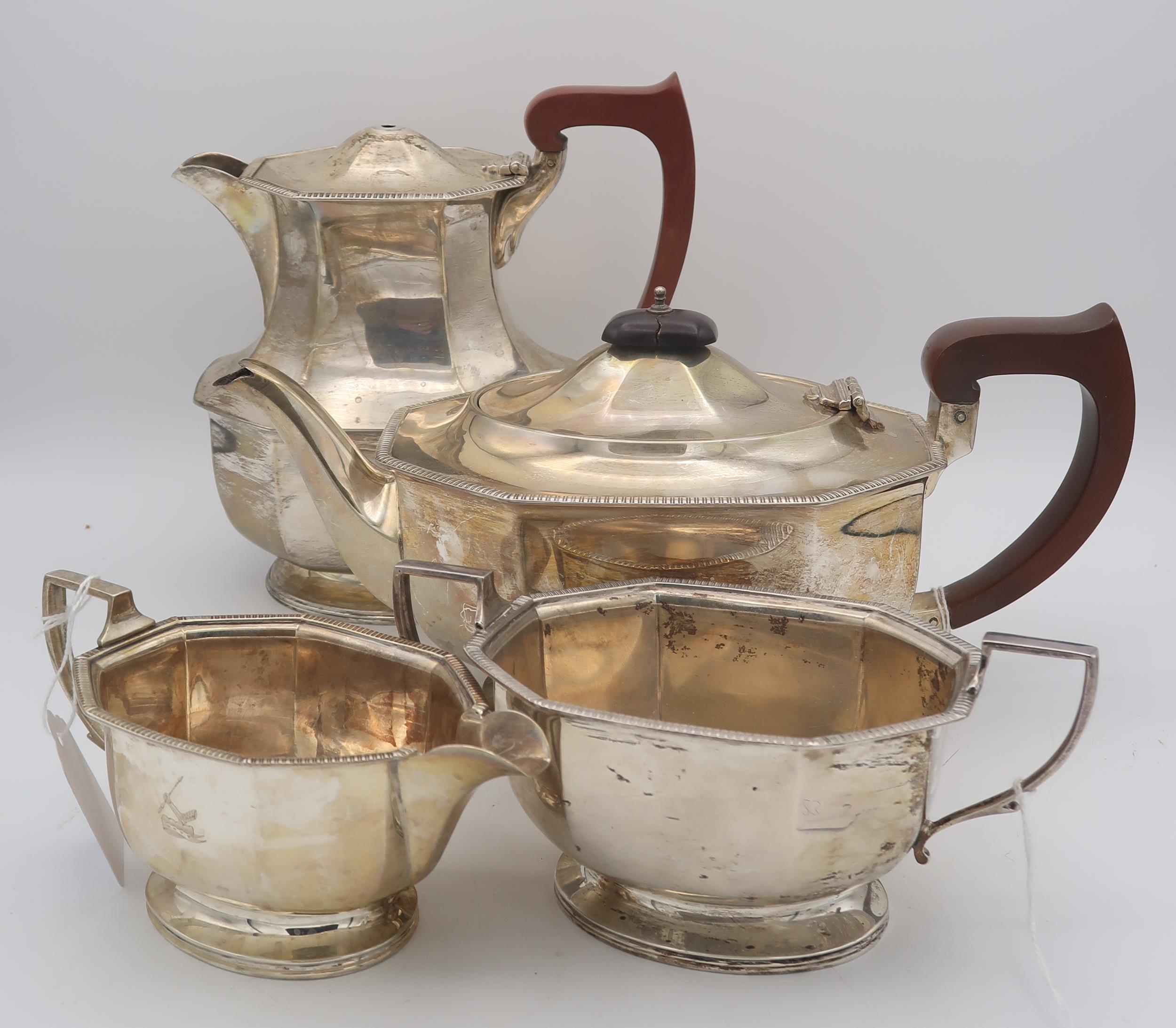 A four piece silver tea service, of faceted form, with engraved crest, by Adie Brothers,