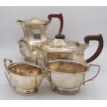 A four piece silver tea service, of faceted form, with engraved crest, by Adie Brothers,