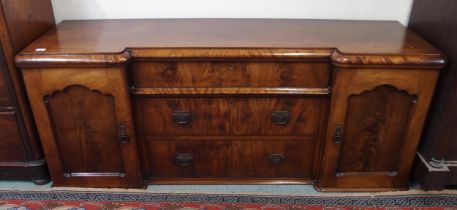 A Victorian mahogany inverted breakfront sideboard with two cabinet doors flanking three central