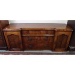 A Victorian mahogany inverted breakfront sideboard with two cabinet doors flanking three central