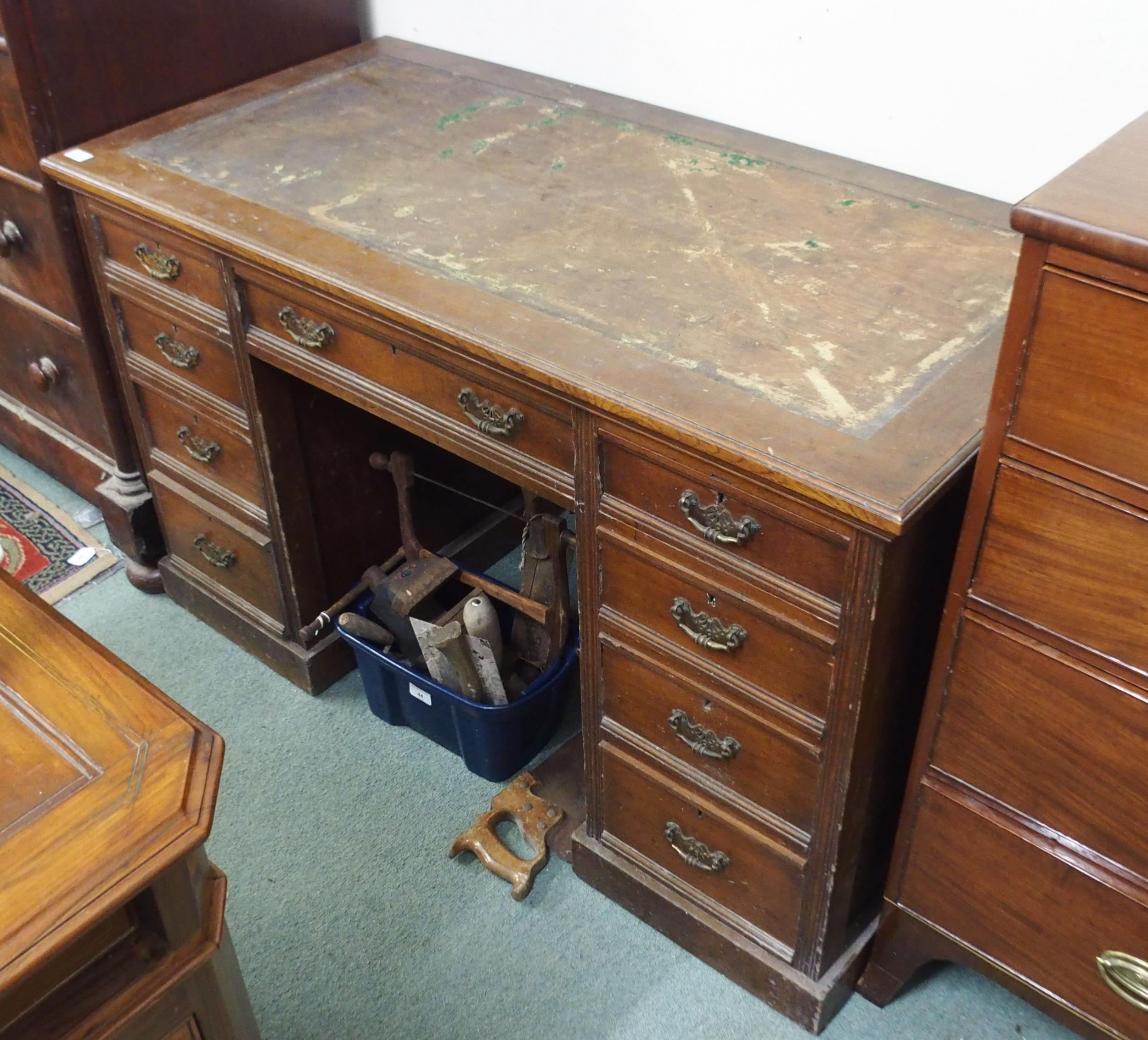 A Victorian oak twin pedestal desk with central drawer containing writing slope flanked by four