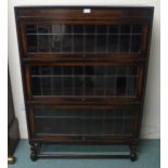 A 20th century oak three tier leaded glass fall front bookcase on stretchered barley twist supports,