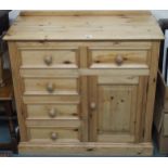 A 20th century pine bedroom chest with two short drawers over three short drawers beside cabinet