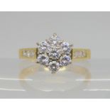 An 18ct gold diamond flower ring, set with 0.94cts of princess and brilliant cut diamonds, size N1/