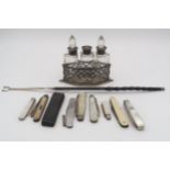 An Edwardian silver and glass three bottle condiment set, comprising three silver collared