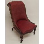 A Victorian mahogany framed slipper chair with floral foliate embossed upholstery on turned supports