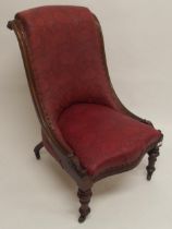 A Victorian mahogany framed slipper chair with floral foliate embossed upholstery on turned supports