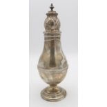 A large silver caster, of baluster form, the lid with pierced geometric decoration, with a turned
