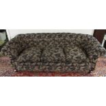 A Victorian button back three seater settee upholstered in a black and gilt acanthus leaves fabric