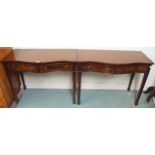 A pair of 20th century mahogany serpentine front two drawer hall tables on square tapering