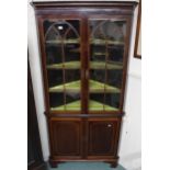 A late Victorian mahogany corner cabinet with pair of glazed doors over cabinet doors on bracket