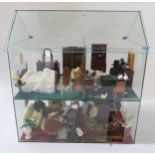 A two-story glass dolls house, approx. 58cm high, containing a quantity of furniture etc.,