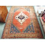A terracotta ground Belouche rug with geometric central medallion light blue spandrels and beige