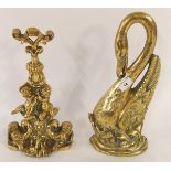 A cast brass door stop in the form of a swan and another depicting cherubs on stylized twined