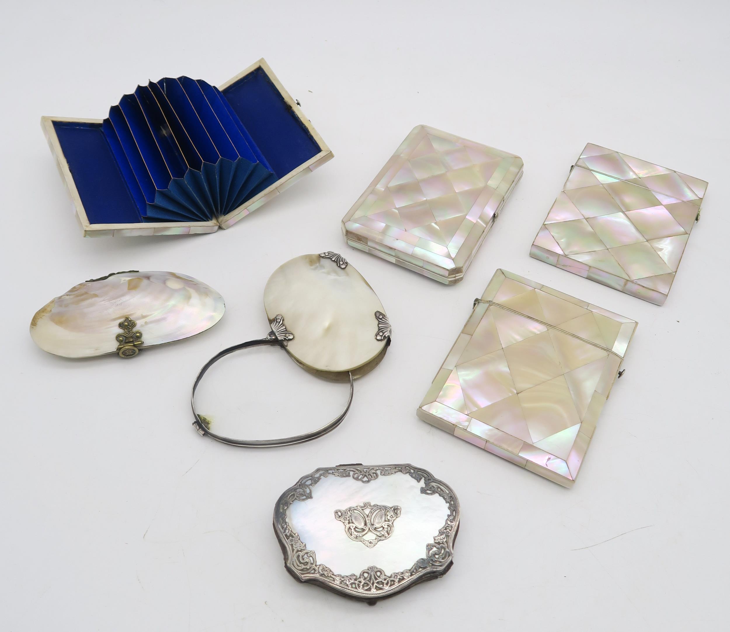 A collection of mother of pearl items, comprising two card cases, two white metal-mounted concertina