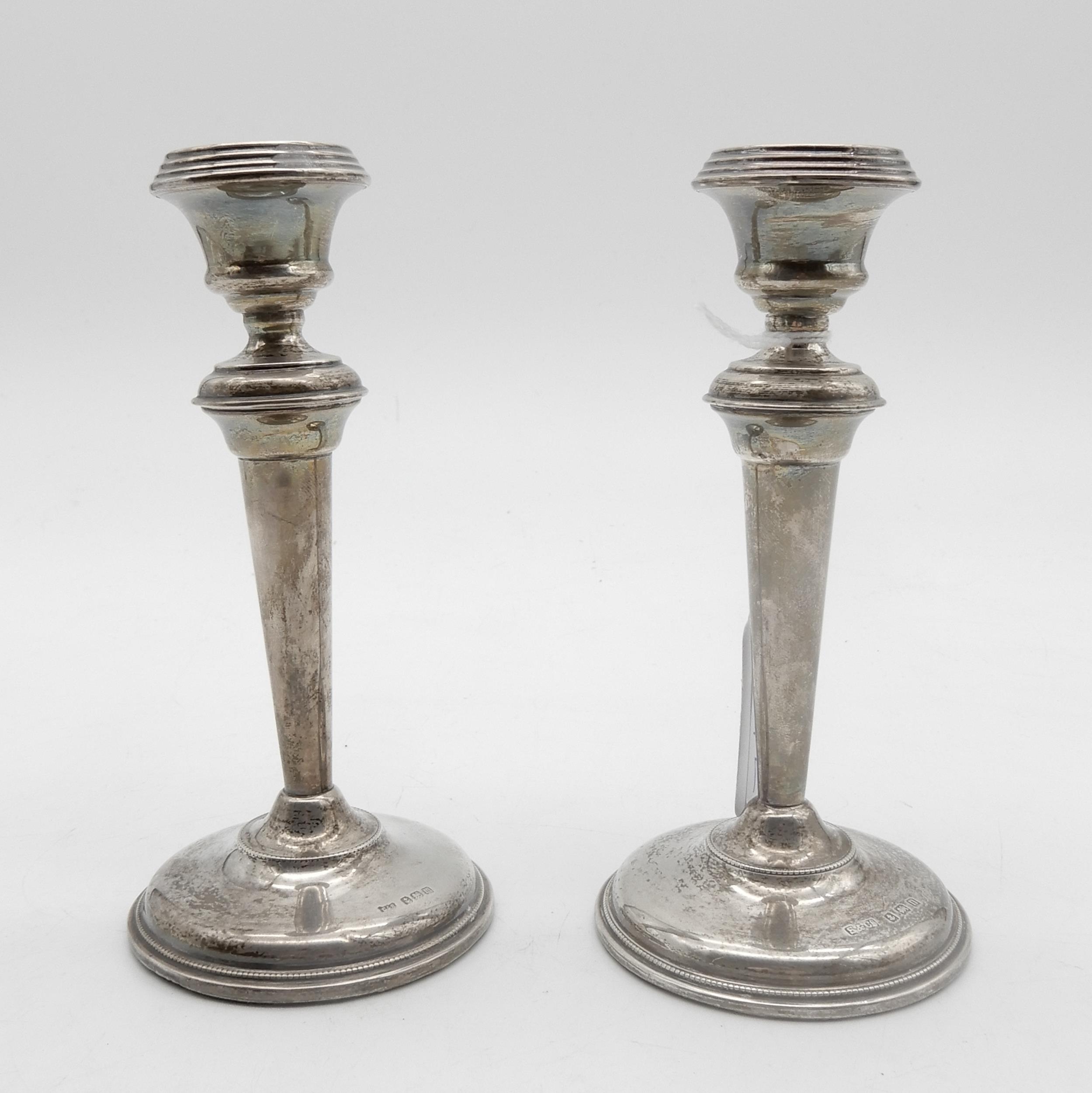 A matched pair of silver candlesticks, of tapering cylindrical form, on a stepped circular base with