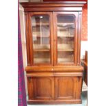 A Victorian glazed bookcase with shaped cornice over pair of glazed doors over pair of drawers