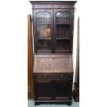 A 20th century stained oak bureau bookcase with glazed two door bookcase top over fall front writing